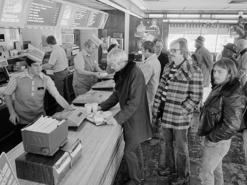 view-along-counter-mcdonalds-fast-food-restaurant-employees-serve-line-customers-1979-3093182